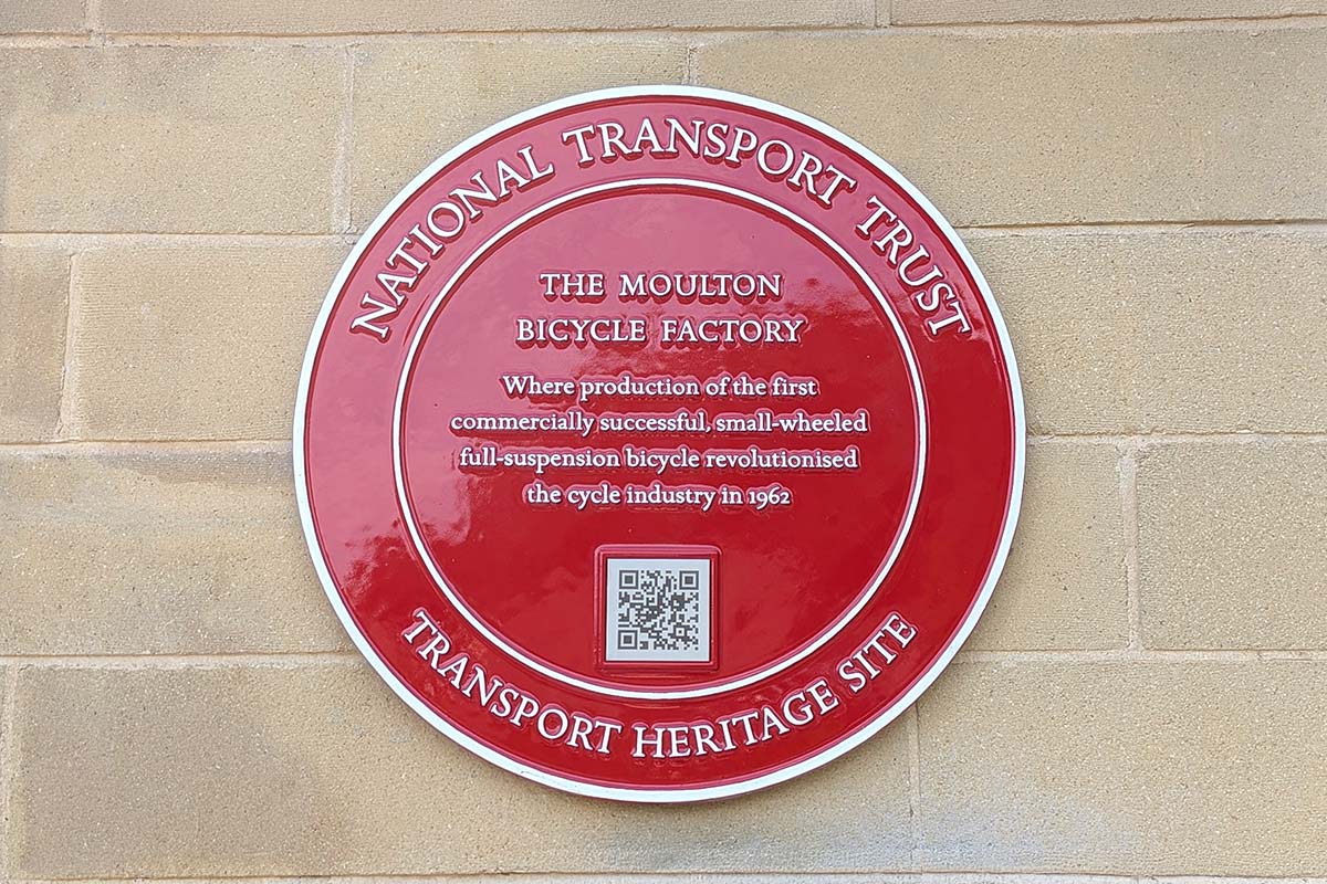 National Transport Trust Red Wheel plaque on Moulton Bicycles factory wall.